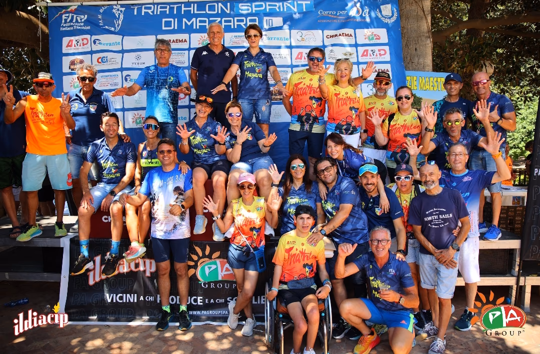 La squadra dell'APD Triathlon Mazara riunita davanti allo striscione della gara